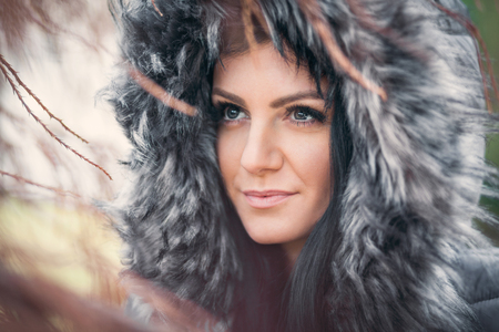 Beautiful young woman wearing a fur hood winter coatの写真素材