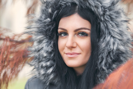 Beautiful young woman wearing a fur hood winter coatの写真素材