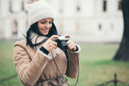 Female photographer taking pictures outdoors with an old vintage cameraの写真素材