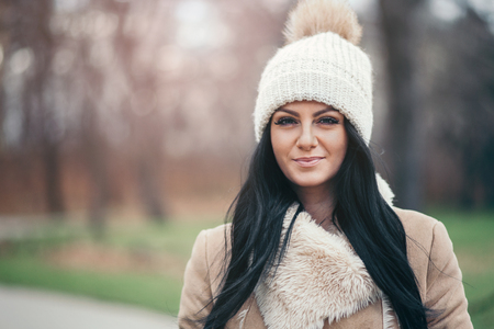 Outdoor portrait of a young woman wearing a coat and hatの写真素材