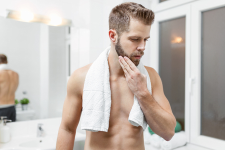 Morning hygiene, Handsome man in the bathroom looking in mirrorの写真素材