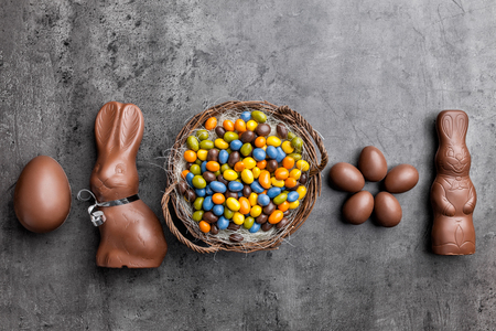 Delicious chocolate Easter bunny, eggs and sweets on rustic backgroundの写真素材