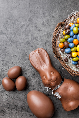 Delicious chocolate Easter bunny, eggs and sweets on rustic backgroundの写真素材