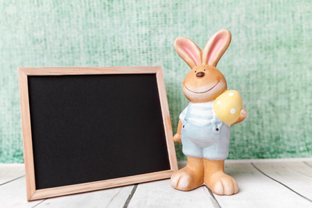Traditional Easter holiday bunny and an empty blackboardの写真素材