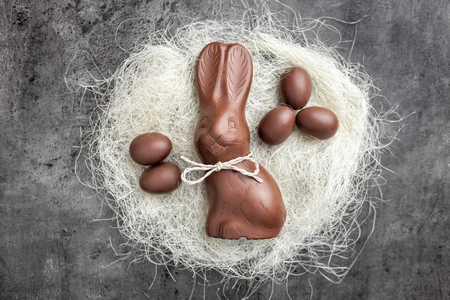 Delicious chocolate Easter bunny and eggs in a nest on rustic backgroundの写真素材
