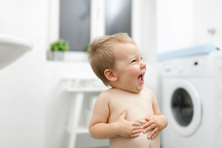 Cute toddler in the batroom getting excited before a bathの写真素材
