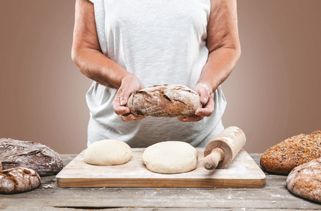 Baker preparing a variety delicious fresh bread and pastryの写真素材