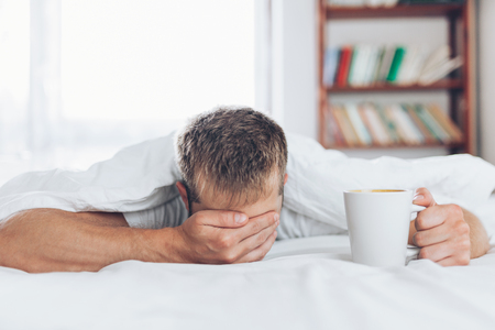 Man trying to wake up in the morning after night outの写真素材
