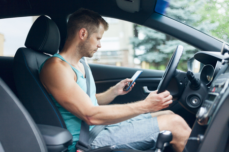 Careless driver using his mobile phone whilst driving a carの写真素材