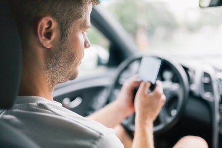 Careless driver using his mobile phone whilst driving a carの写真素材