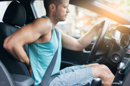 Man with lots of back pain after a long drive in carの写真素材