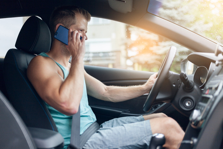 Careless driver using his mobile phone whilst driving a carの写真素材
