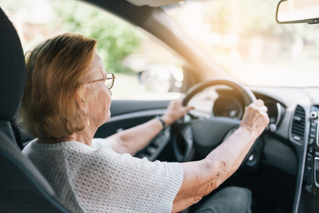 Elderly woman behind the steering wheel of a carの写真素材