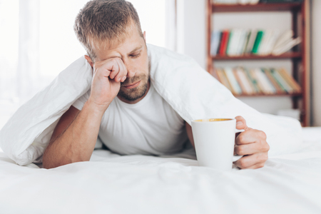 Man trying to wake up in the morning after night outの写真素材