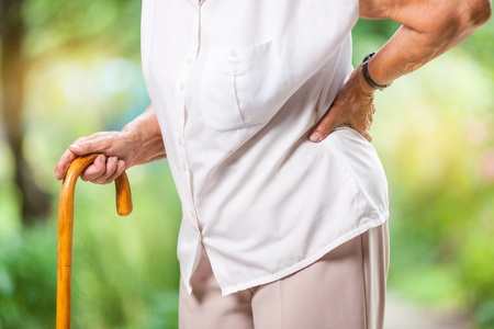 Elderly woman outdoors with lower back painの写真素材