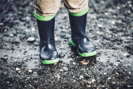 Close up on toddler wearing rubber boots in rainy weatherの写真素材