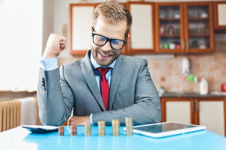 Working from home. Young businessman checking on returns from his investmentの写真素材