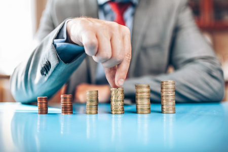 Businessman and his financial investment on the tableの写真素材