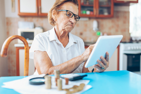 Senior woman at home checking her finances and investmentsの写真素材