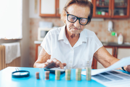 Senior woman at home checking her finances and investmentsの写真素材