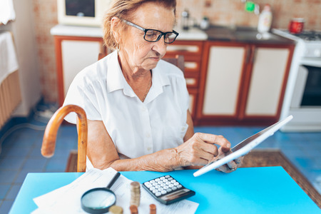 Senior woman at home checking her finances and investmentsの写真素材