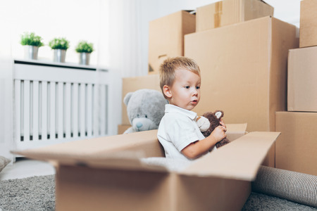 Cute toddler helping out packing boxes and moving