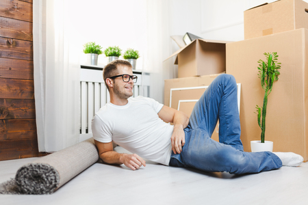 Handsome young man moving into his new homeの写真素材