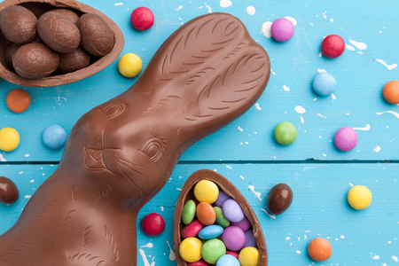 Delicious chocolate Easter bunny, eggs and sweets on rustic backgroundの写真素材