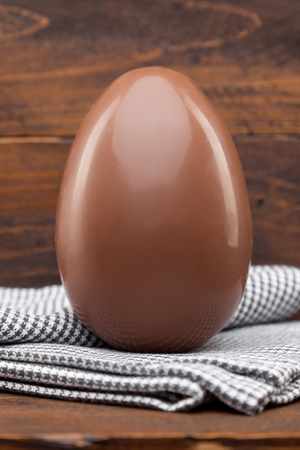 Delicious chocolate Easter holiday egg on rustic backgroundの写真素材