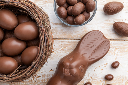 Delicious chocolate Easter bunny, eggs and sweets on rustic backgroundの写真素材