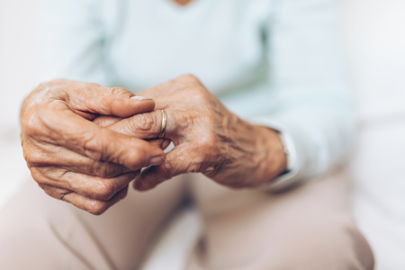 Heartbroken elderly woman holding he husbands wedding ringの写真素材