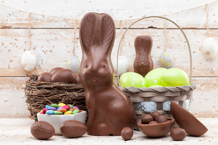 Delicious chocolate Easter bunny, eggs and sweets on rustic backgroundの写真素材
