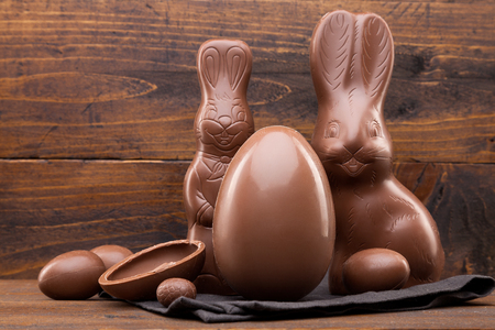 Delicious chocolate Easter bunny, eggs and sweets on rustic backgroundの写真素材