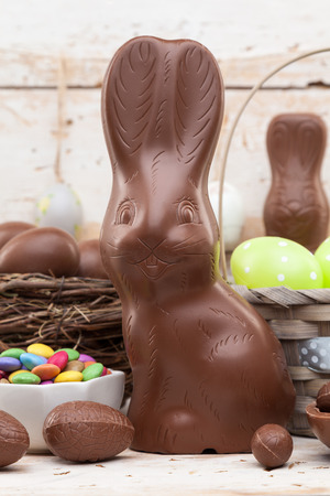 Delicious chocolate Easter bunny, eggs and sweets on rustic backgroundの写真素材