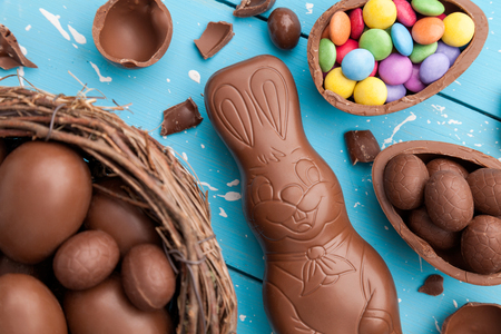 Delicious chocolate Easter bunny, eggs and sweets on rustic backgroundの写真素材