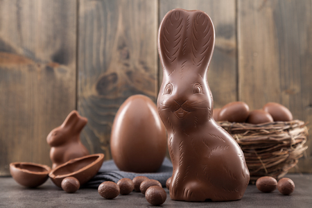 Delicious chocolate Easter bunny, eggs and sweets on rustic backgroundの写真素材