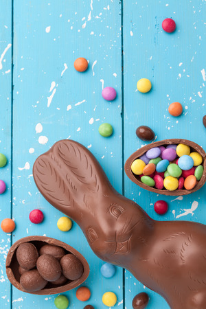 Delicious chocolate Easter bunny, eggs and sweets on rustic backgroundの写真素材