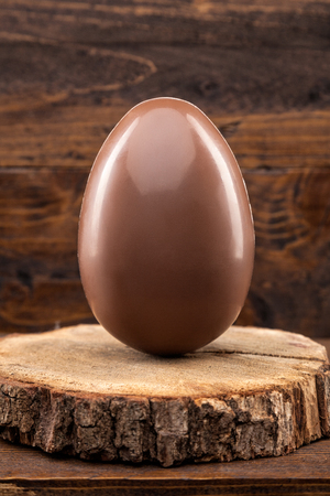 Delicious chocolate Easter holiday egg on rustic backgroundの写真素材