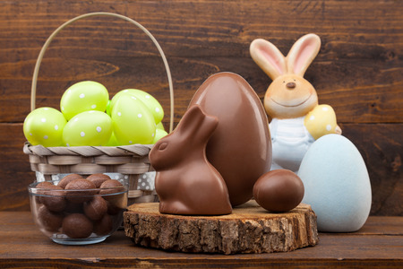 Delicious chocolate Easter bunny, eggs and sweets on rustic backgroundの写真素材