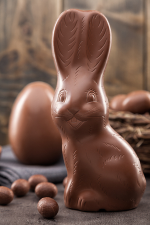 Delicious chocolate Easter bunny, eggs and sweets on rustic backgroundの写真素材