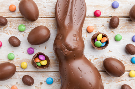Delicious chocolate Easter bunny, eggs and sweets on rustic backgroundの写真素材
