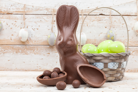 Delicious chocolate Easter bunny, eggs and sweets on rustic backgroundの写真素材