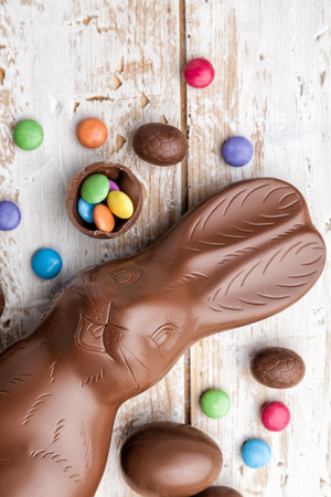 Delicious chocolate Easter bunny, eggs and sweets on rustic backgroundの写真素材