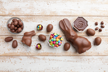 Delicious chocolate Easter bunny, eggs and sweets on rustic backgroundの写真素材