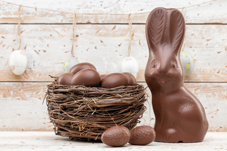 Delicious chocolate Easter bunny, eggs and sweets on rustic backgroundの写真素材
