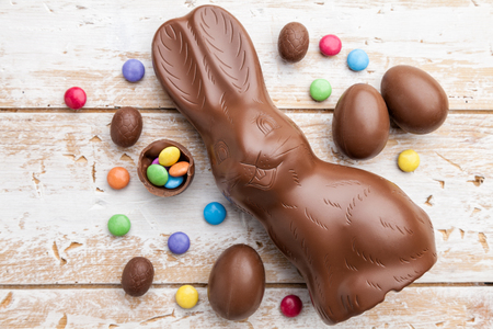 Delicious chocolate Easter bunny, eggs and sweets on rustic backgroundの写真素材