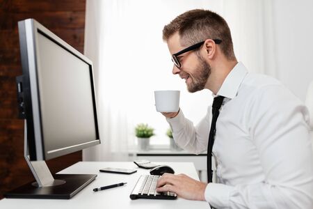 Successful handsome businessman working in his officeの写真素材