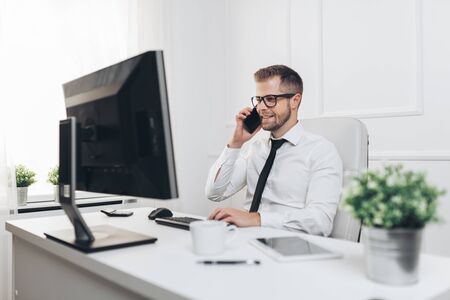 Successful handsome businessman working in his officeの写真素材