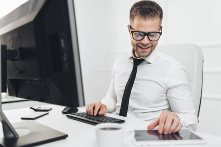 Successful handsome businessman working in his officeの写真素材