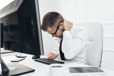 Office worker with back pain from sitting at desk all dayの写真素材